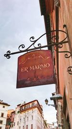 Low angle view of text on building against sky