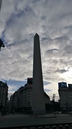 Low angle view of buildings against cloudy sky