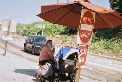 Rear view of men sitting on road