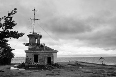 Lighthouse by sea against sky