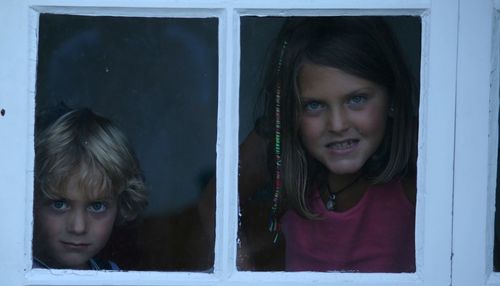 Close-up of girl looking through window