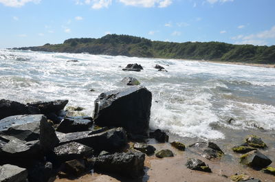 Scenic view of rocks in sea against sky