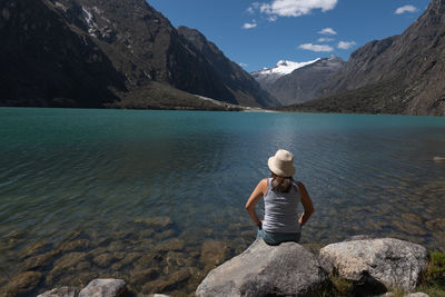 Tourist contemplates the llanganuco lagoon and the calm that it inspires in huaraz, peru.