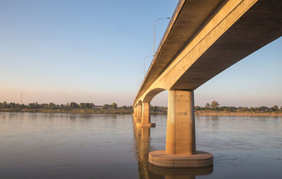 Bridge over river against sky during sunset