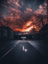 Road by city against sky during sunset