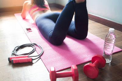 Low section of woman doing yoga on mat