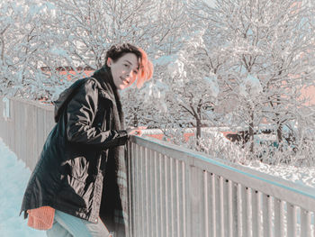 Portrait of smiling woman standing in snow