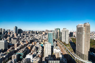 High angle view of modern buildings against clear blue sky