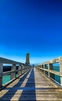 View of pier over sea against blue sky