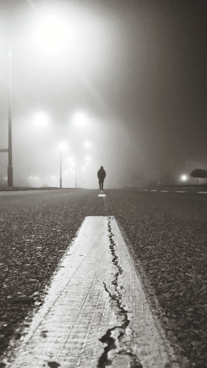 full length, rear view, the way forward, walking, lifestyles, road, sky, surface level, street, leisure activity, night, men, weather, street light, standing, illuminated, dusk, silhouette