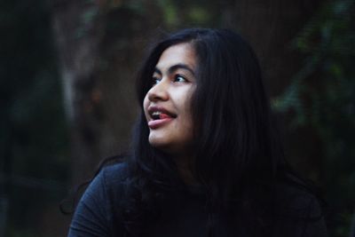 Portrait of young woman looking away in forest