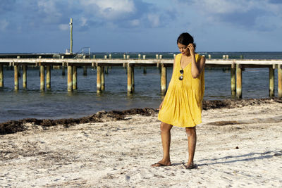 Full length of woman standing at beach