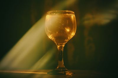 Close-up of beer glass on table with lens flare