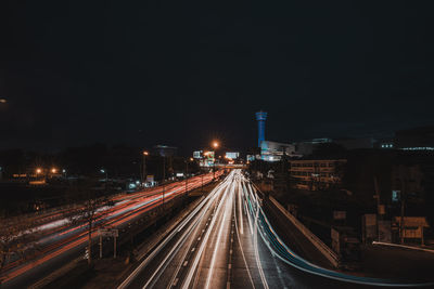 Light trails on road against sky at night