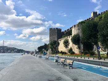 Road by buildings against sky in city