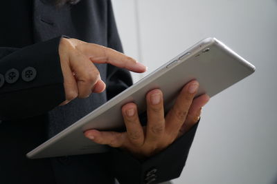 Midsection of businessman using digital tablet at office