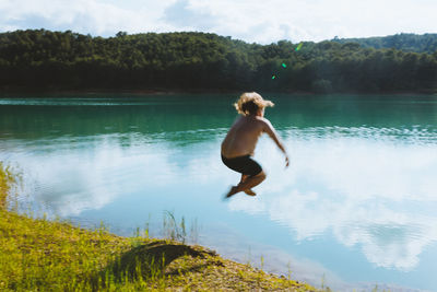 Unrecognizable man falling in lake on sunny day in dolomites in italy