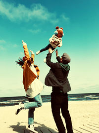 Rear view of woman standing at beach
