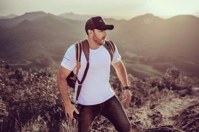 Man wearing cap standing on landscape