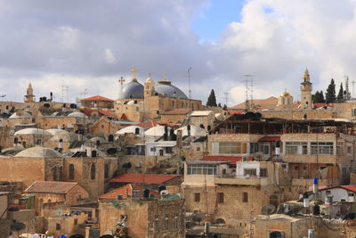 Buildings in city against cloudy sky