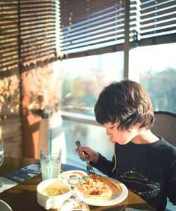 Boy eating food on table