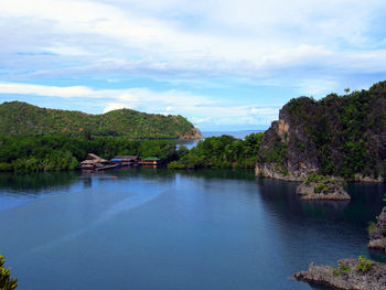 Scenic view of river by trees against sky