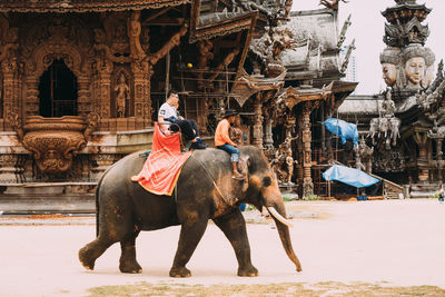Full length of women sitting on traditional building