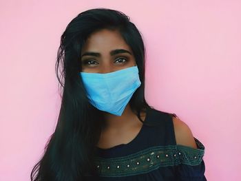 Portrait of a beautiful young woman against pink background