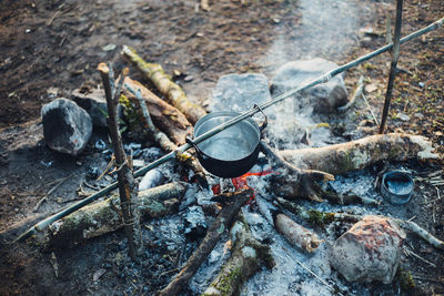 High angle view of cooking pot over burning fire at campsite