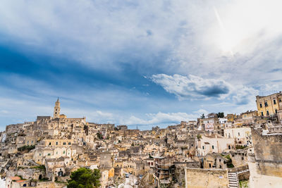 Buildings in town against cloudy sky