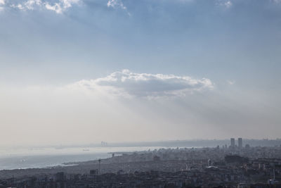 Aerial view of cityscape against sky during foggy weather