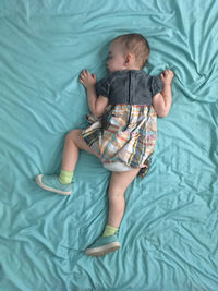 High angle view of baby lying on bed