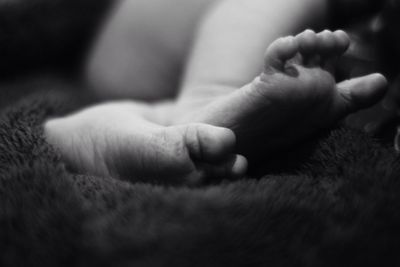 Low section of baby resting on bed