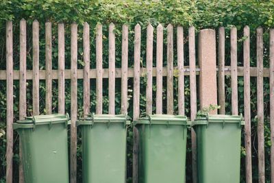 Close-up of trashcan against fence