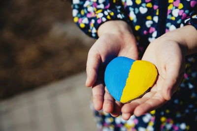 Midsection of woman holding heart shape