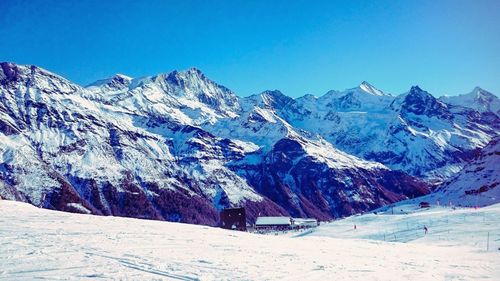 Scenic view of snowcapped mountains against clear blue sky