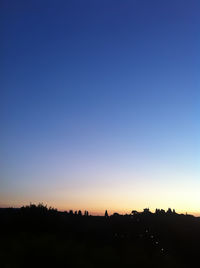 Silhouette landscape against clear blue sky