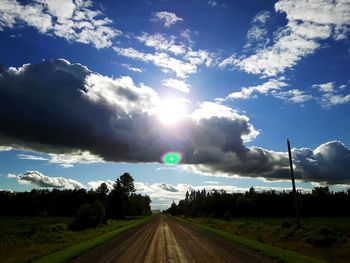 Country road against cloudy sky