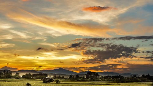 Scenic view of dramatic sky over landscape during sunset