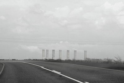 Road by bridge against sky