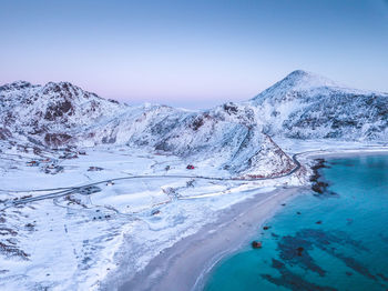 Scenic view of snowcapped mountains against clear sky during sunset