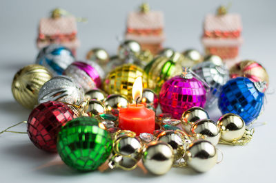 Close-up of lit candle amidst christmas decorations on table