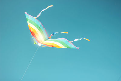 Low angle view of kite flying against clear blue sky