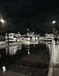 Cars on illuminated road against sky at night