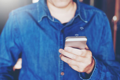 Midsection of man using mobile phone