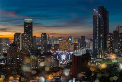 Illuminated buildings in city against sky at night