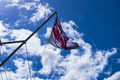 Low angle view of british flag against blue sky