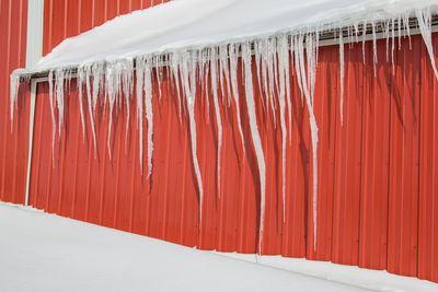 Icicles hanging off of a barn roof.