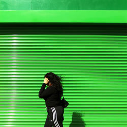 Full length of woman standing against wall