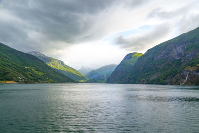 Scenic view of lake by mountains against sky